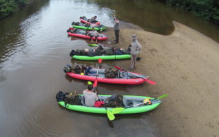 an image of seven adventurers getting kayaks ready for the jungle river