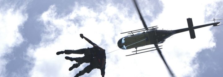 an image of two men jumping out of a hovering helicopter