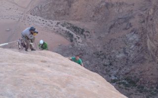 an image of filming explorers abseiling down dessert mountains