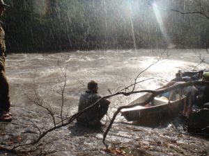 an image of a man sat by a river in the rain during a Bushmasters jungle survival course